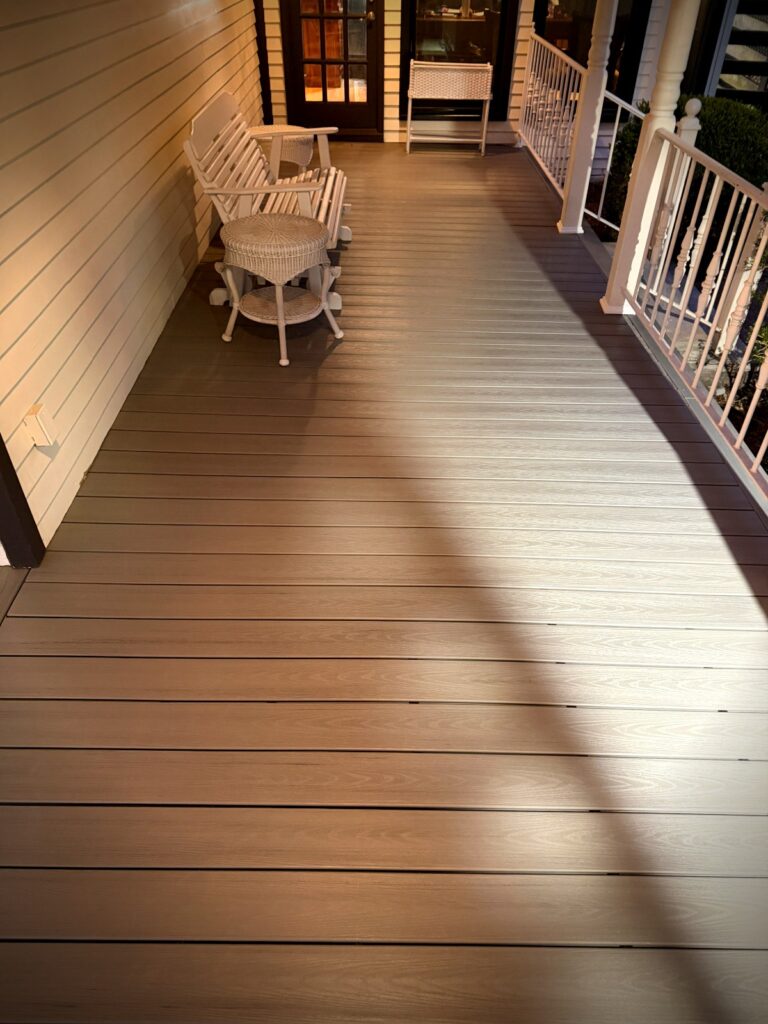 Composite porch deck replacement with white spindle railing at evening Proper Deck and Fence Tennessee