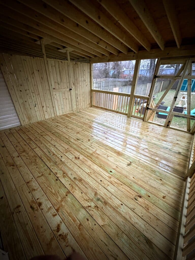 Interior view of new screened porch with wood flooring and backyard views Middle Tennessee
